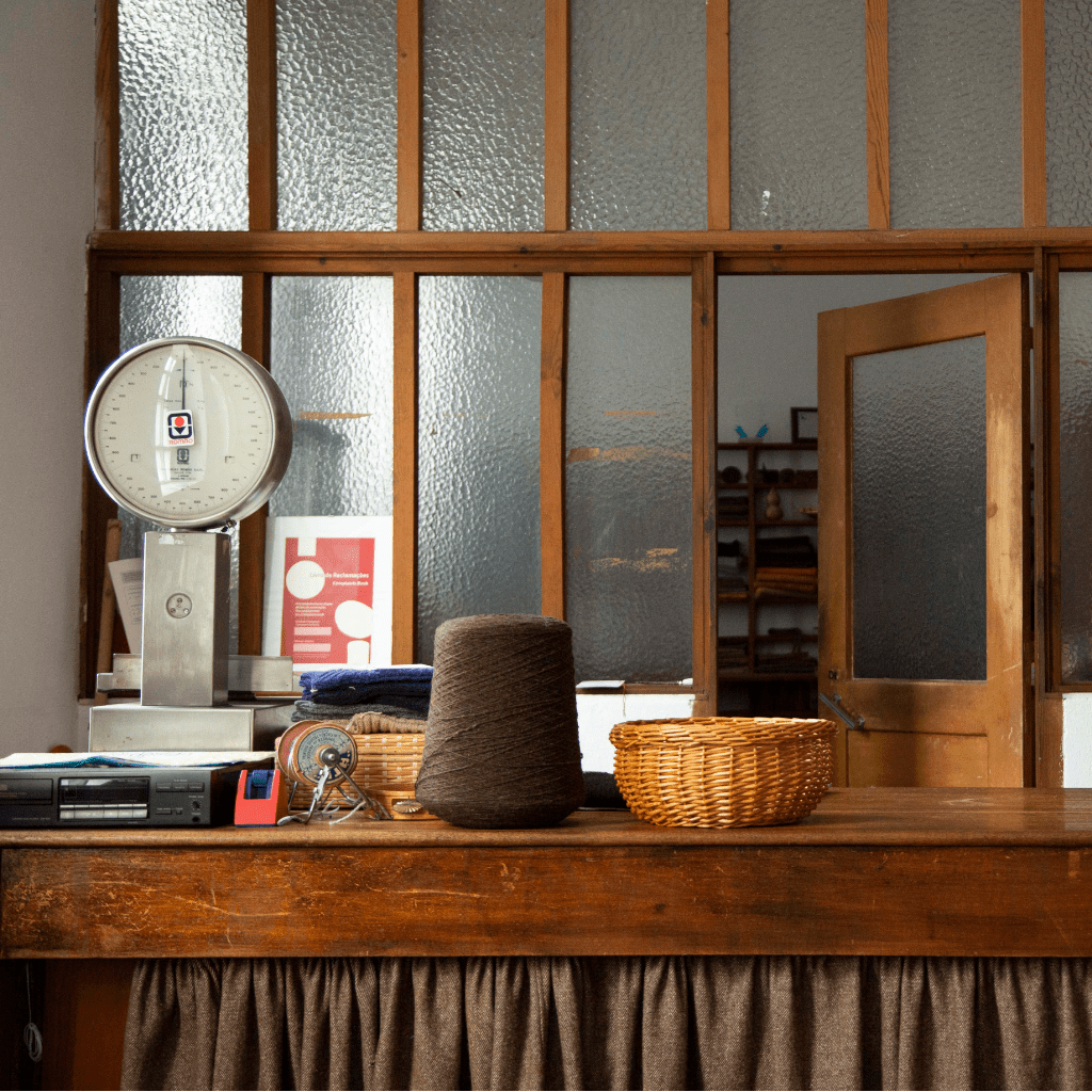 Auf einer Theke sieht man Wolle, Waage und eine Durchreiche.